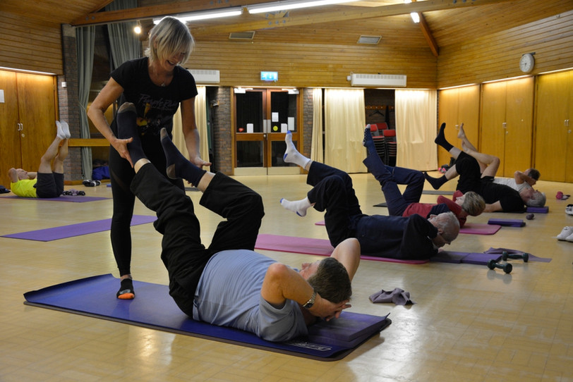 Man performing a controlled Pilates exercise during a men’s class